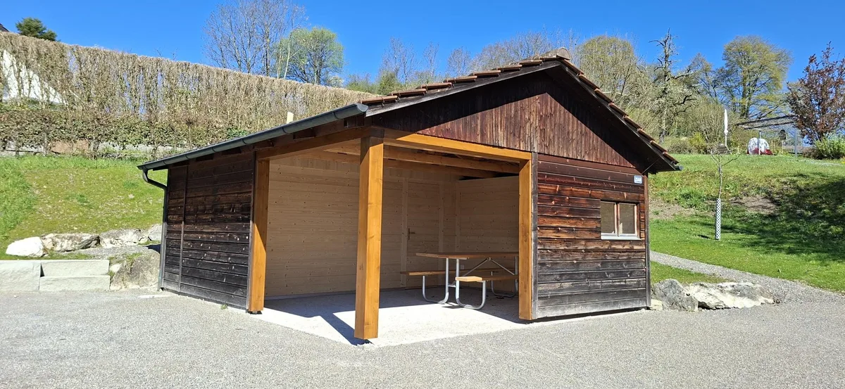 Der neue Spielplatz in Ottikon: Man sieht eine Holzhütte mit Laube.